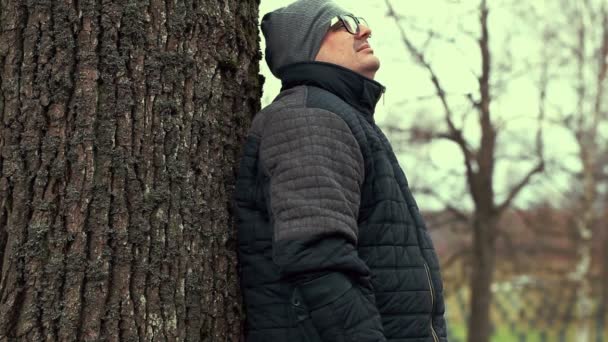 Homme seul handicapé avec des béquilles près d'un arbre 