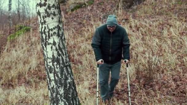 Huş ağacı, koltuk değneği ile Engelli yalnız adam — Stok video