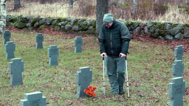 Ancien combattant handicapé au monument de la tombe avec des fleurs — Video