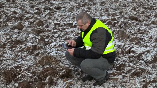 Landbouwproducent met gebruikmaking van tablet Pc op bevroren veld — Stockvideo
