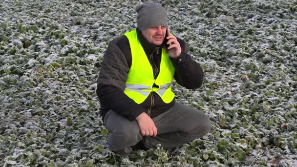 Agricultor con smartphone en campo congelado — Vídeo de stock