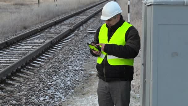 Trabajador con smartphone cerca del ferrocarril — Vídeos de Stock