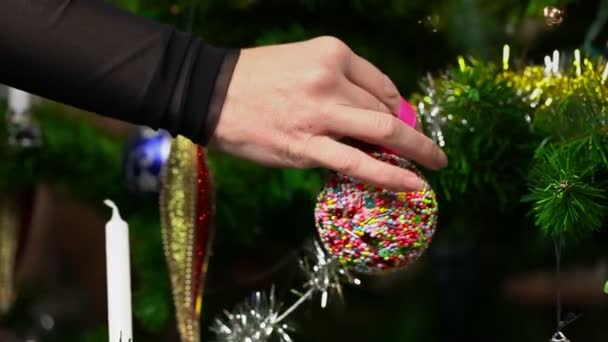 Mujer con decoraciones de árbol de Navidad en el árbol de Navidad — Vídeo de stock