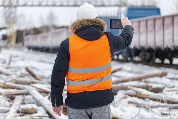 Engineer filmed on the tablet PC near the freight wagons — Stock Photo, Image