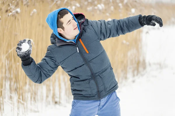 Teenager throw snowballs in winter day — Stock Photo, Image