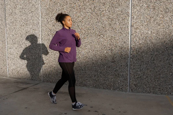 young African american woman running outdoors  - Fitness, people