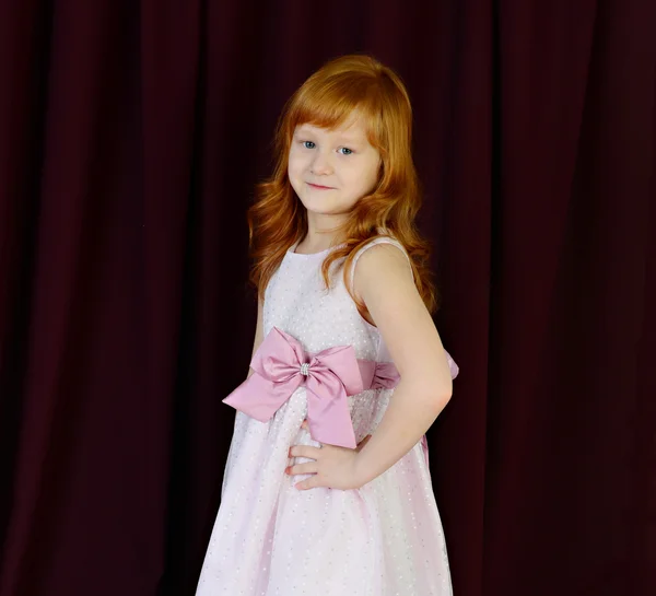 Porträtt av rödhårig flicka på en röd bakgrund — Stockfoto