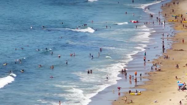 Gente disfrutando de un día soleado en la playa — Vídeo de stock