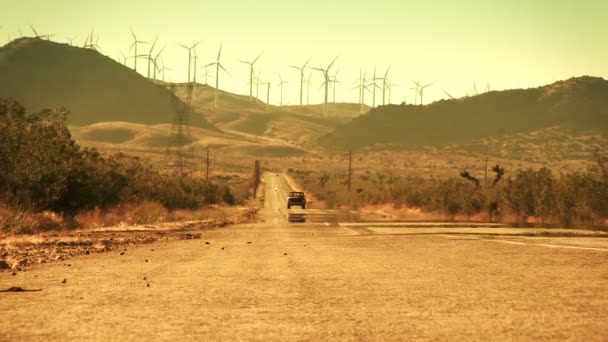 Грузовик едет по пустынной дороге от ветроэлектростанции — стоковое видео