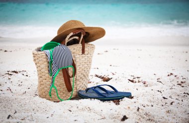 Hasır şapka ve çanta bir tropikal plaj