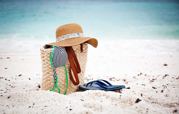 Strohhut und Tasche am tropischen Strand — Stockfoto