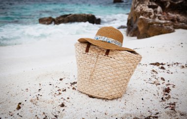 Hasır şapka ve çanta bir tropikal plaj