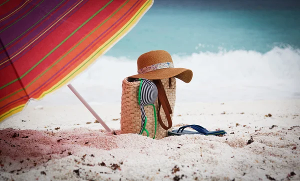 Strohhut und Tasche am tropischen Strand — Stockfoto