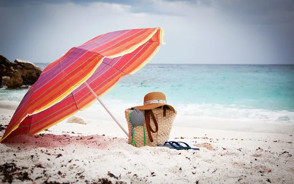 Straw hat and bag on a tropical beach — Stock Photo, Image