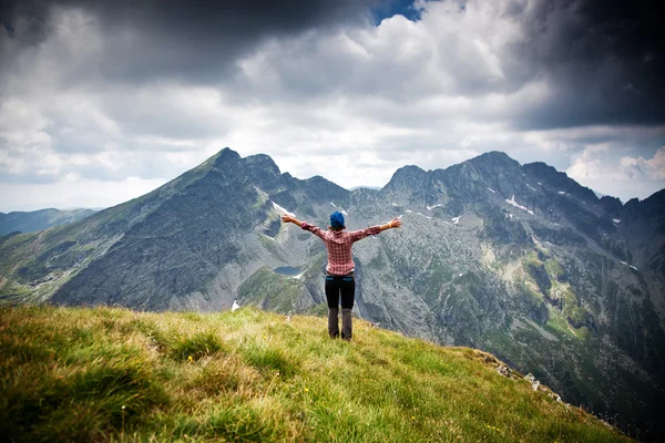 Kobieta wycieczkowicz relaksujący na szczycie góry podziwiać otaczające skaliste szczyty — Zdjęcie stockowe