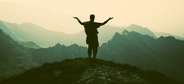 Турист на вершине с видом на скалистые горы — стоковое фото