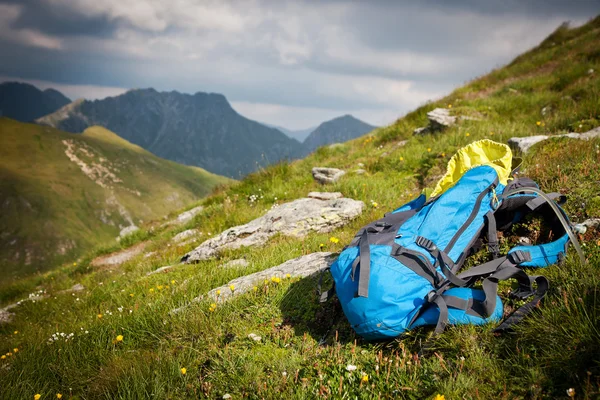 Sırt çantası veya sırt çantası bir kaya üzerine bir dağ zirvesine karşı dengeli