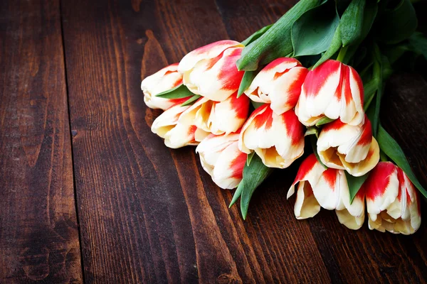 Букет з різнокольорових тюльпанів на сільській дерев'яній дошці, великодні прикраси — стокове фото