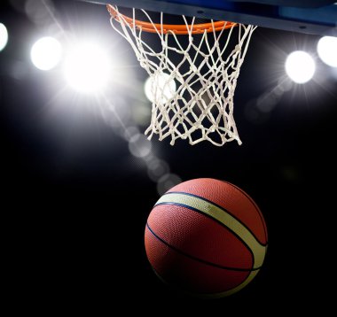 Basketbol bir spor sahasında çemberin içinden geçiyor