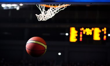 Basketbol bir spor sahasında çemberin içinden geçiyor
