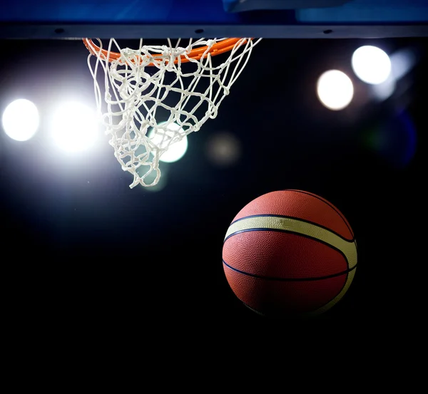 Basquete passando pelo aro em uma arena de esportes — Fotografia de Stock