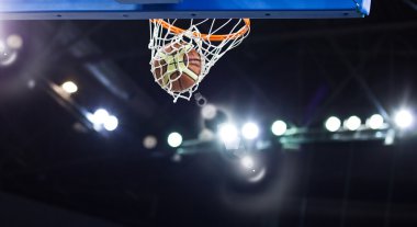 Basketbol bir spor sahasında çemberin içinden geçiyor