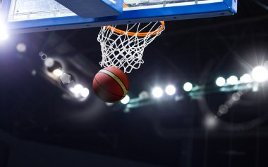 Basketbol bir spor sahasında çemberin içinden geçiyor