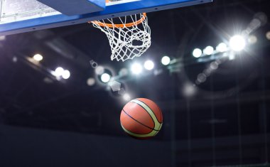 Basketbol bir spor sahasında çemberin içinden geçiyor