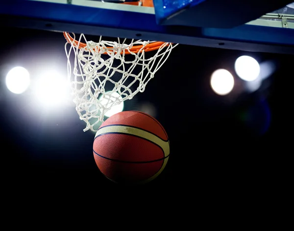 Basquete passando pelo aro em uma arena de esportes — Fotografia de Stock