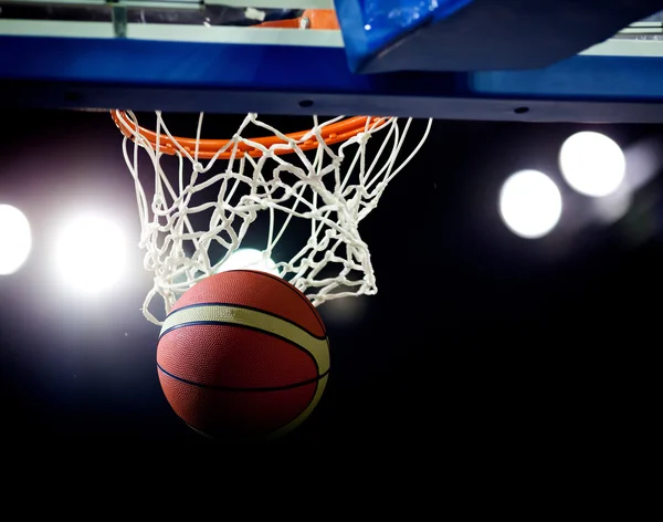 Basquete passando pelo aro em uma arena de esportes — Fotografia de Stock