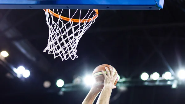 Basquete passando pelo aro em uma arena de esportes — Fotografia de Stock