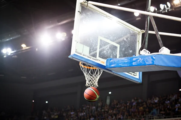 Basketbal prochází obručí ve sportovní aréně — Stock fotografie