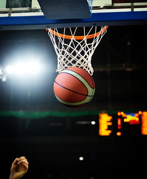 Basketbol bir spor sahasında çemberin içinden geçiyor — Stok fotoğraf