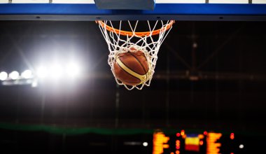 Basketbol bir spor sahasında çemberin içinden geçiyor