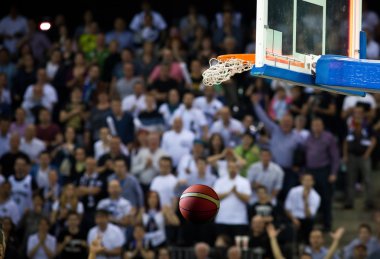 Basketbol bir spor sahasında çemberin içinden geçiyor