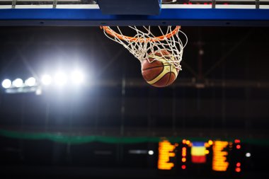 Basketbol bir spor sahasında çemberin içinden geçiyor