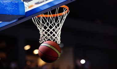Basketbol bir spor sahasında çemberin içinden geçiyor