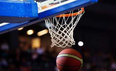 Basketbol bir spor sahasında çemberin içinden geçiyor