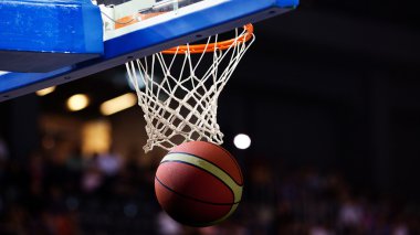 Basketbol bir spor sahasında çemberin içinden geçiyor