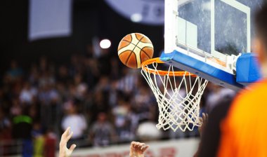 Basketbol bir spor sahasında çemberin içinden geçiyor