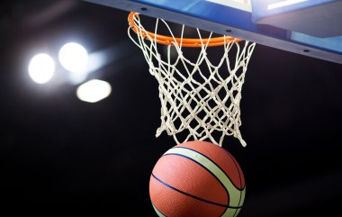 Basketbol bir spor sahasında çemberin içinden geçiyor