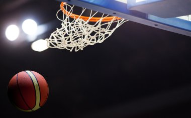 Basketbol bir spor sahasında çemberin içinden geçiyor