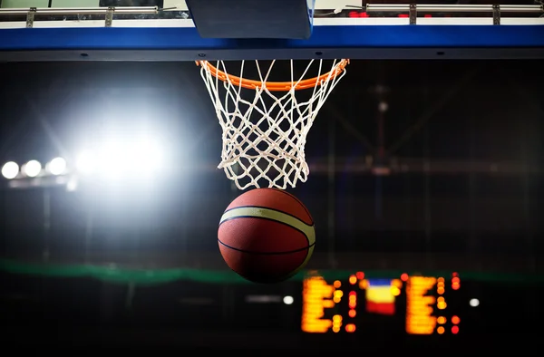 Basketbal prochází obručí ve sportovní aréně — Stock fotografie