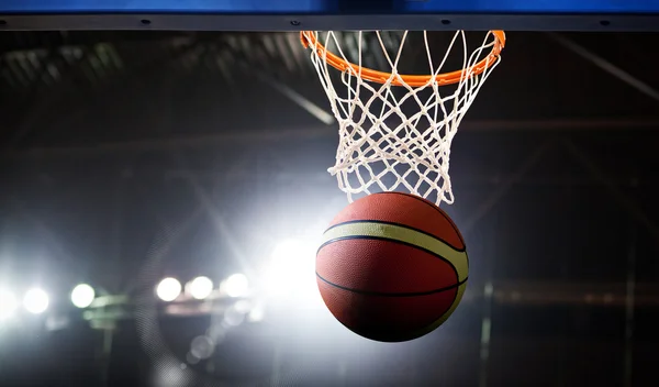 Basketball going through the hoop at a sports arena — Stock Photo, Image