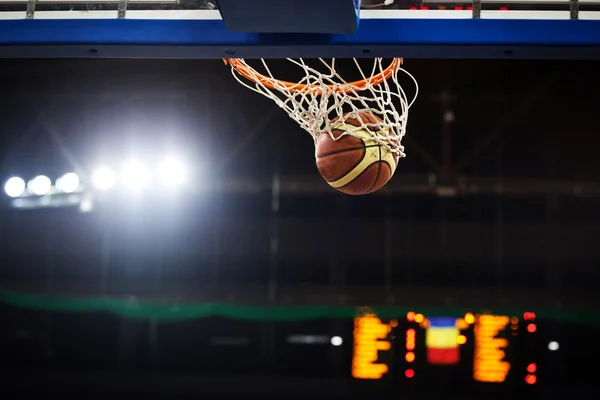 Basketball going through the hoop at a sports arena — Stock Photo, Image