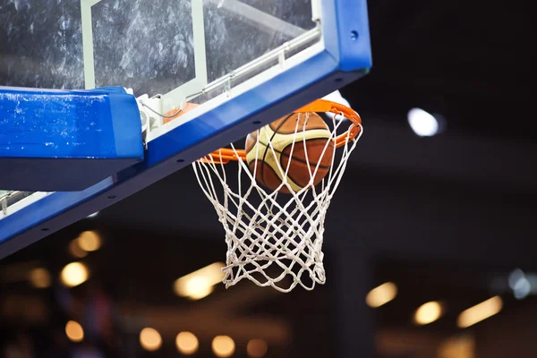 Basketball going through the hoop at a sports arena — Stock Photo, Image