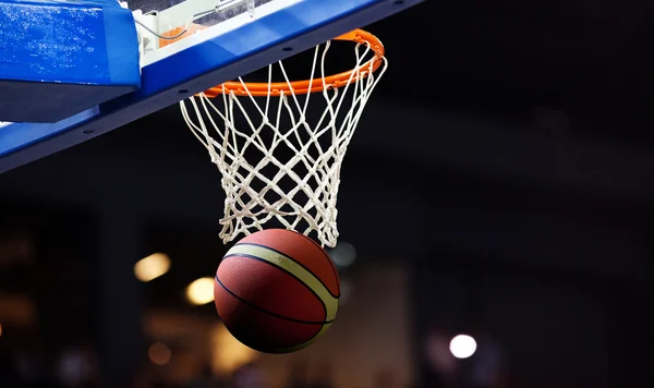 Basketball going through the hoop at a sports arena — Stock Photo, Image