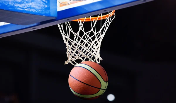 Basketball going through the hoop at a sports arena — Stock Photo, Image