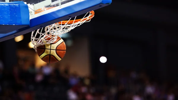 Баскетбол проходит через обруч на спортивной арене — стоковое фото