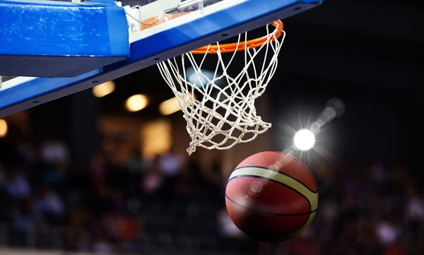 Basketball going through the hoop at a sports arena — Stock Photo, Image